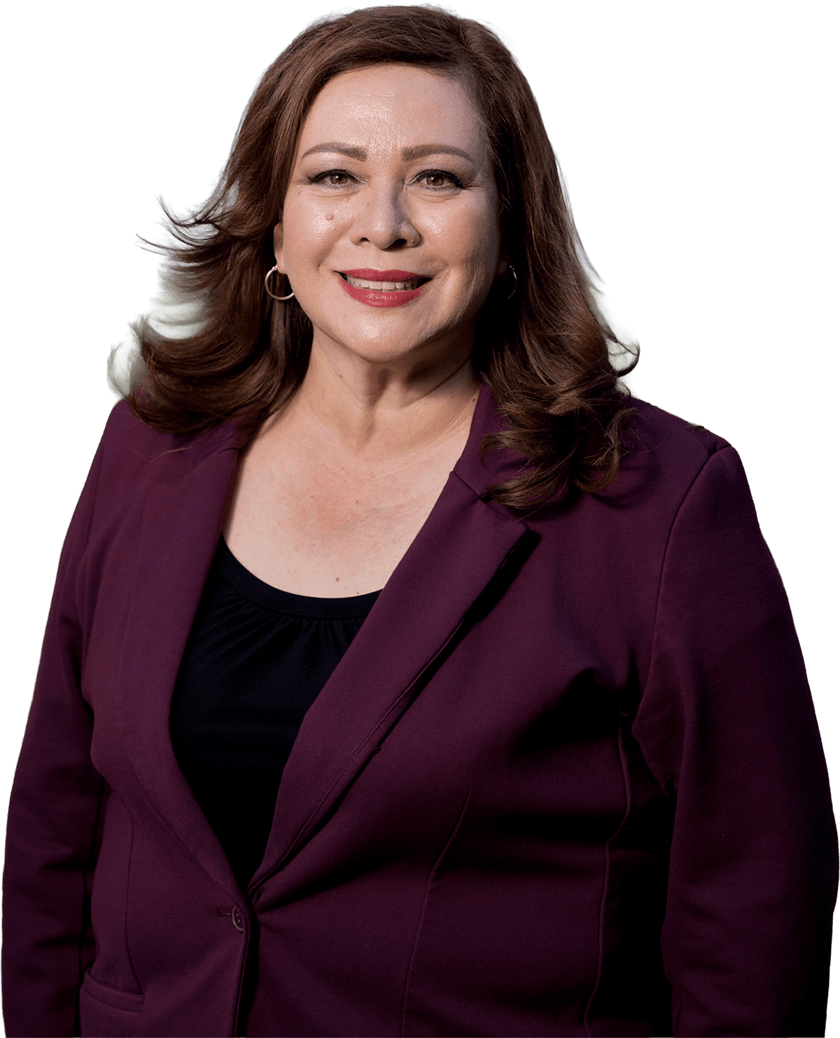 Portrait of Sandra Armenta smiling outdoors, wearing a burgundy blazer over a black top with trees softly blurred in the background.